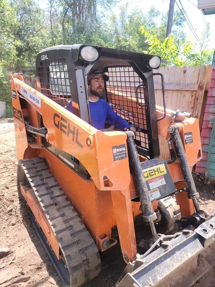 ZH Restoration operating a skid steer during a site grading and excavation job