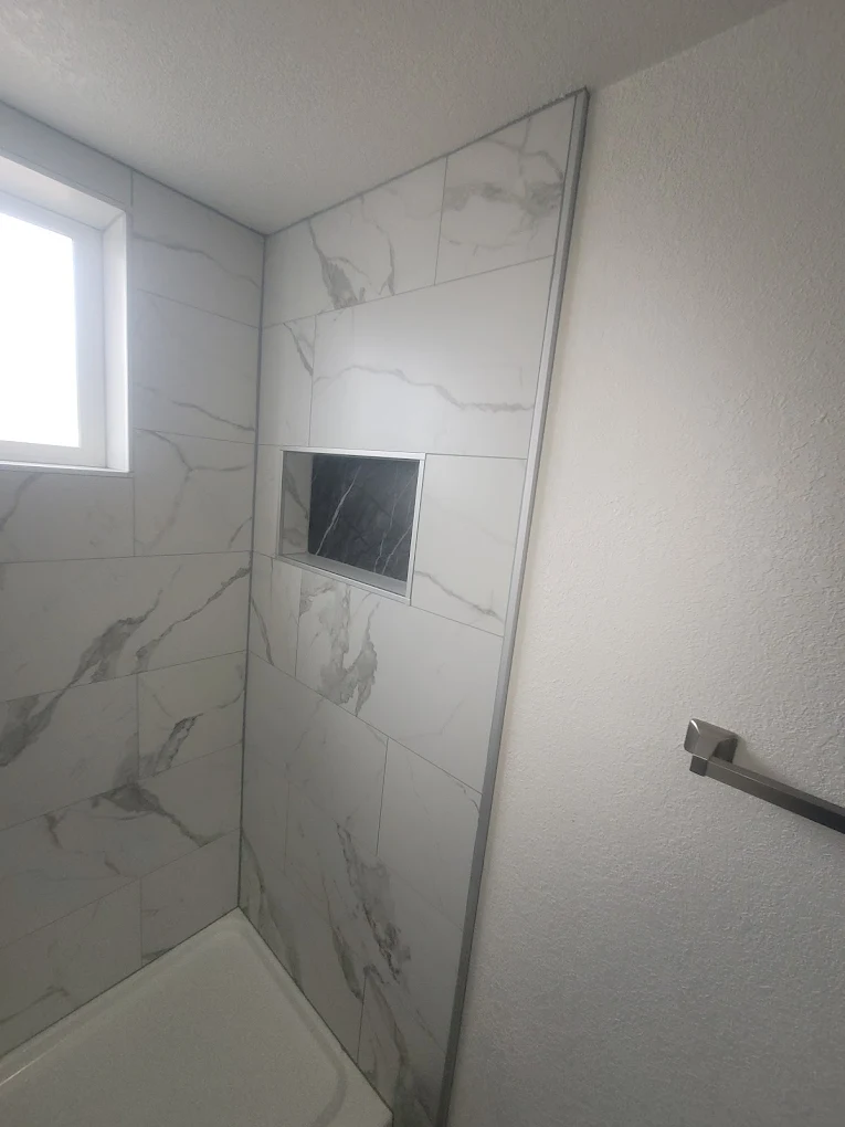 Custom tiled shower with built-in marble niche